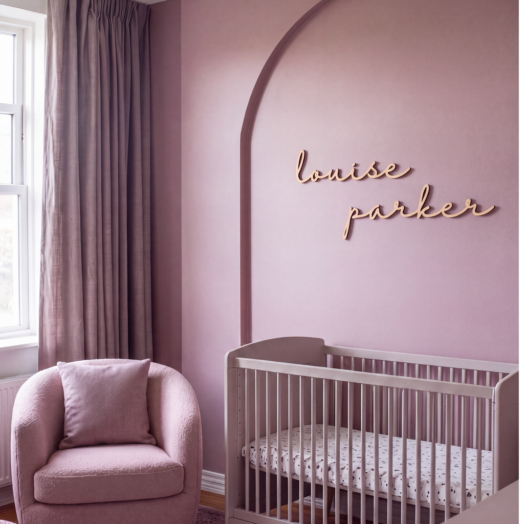 Wood baby name sign reading louise parker on a mauve nursery wall with an arch detail