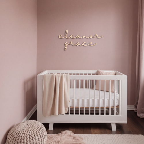 Custom baby name sign reading eleanor grace on a dusty pink nursery wall above a white crib