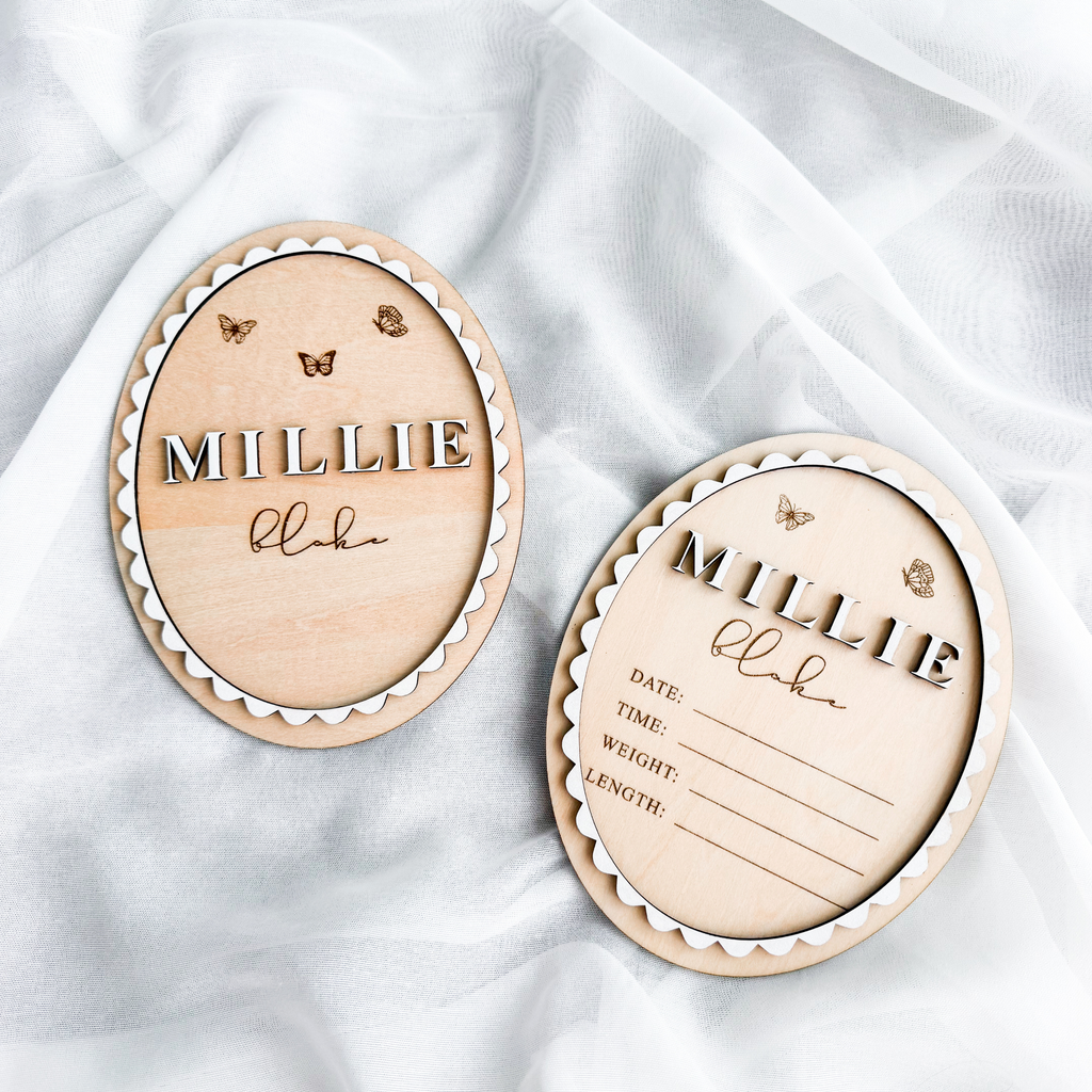Butterfly baby name sign and matching birth stats sign side by side on white fabric