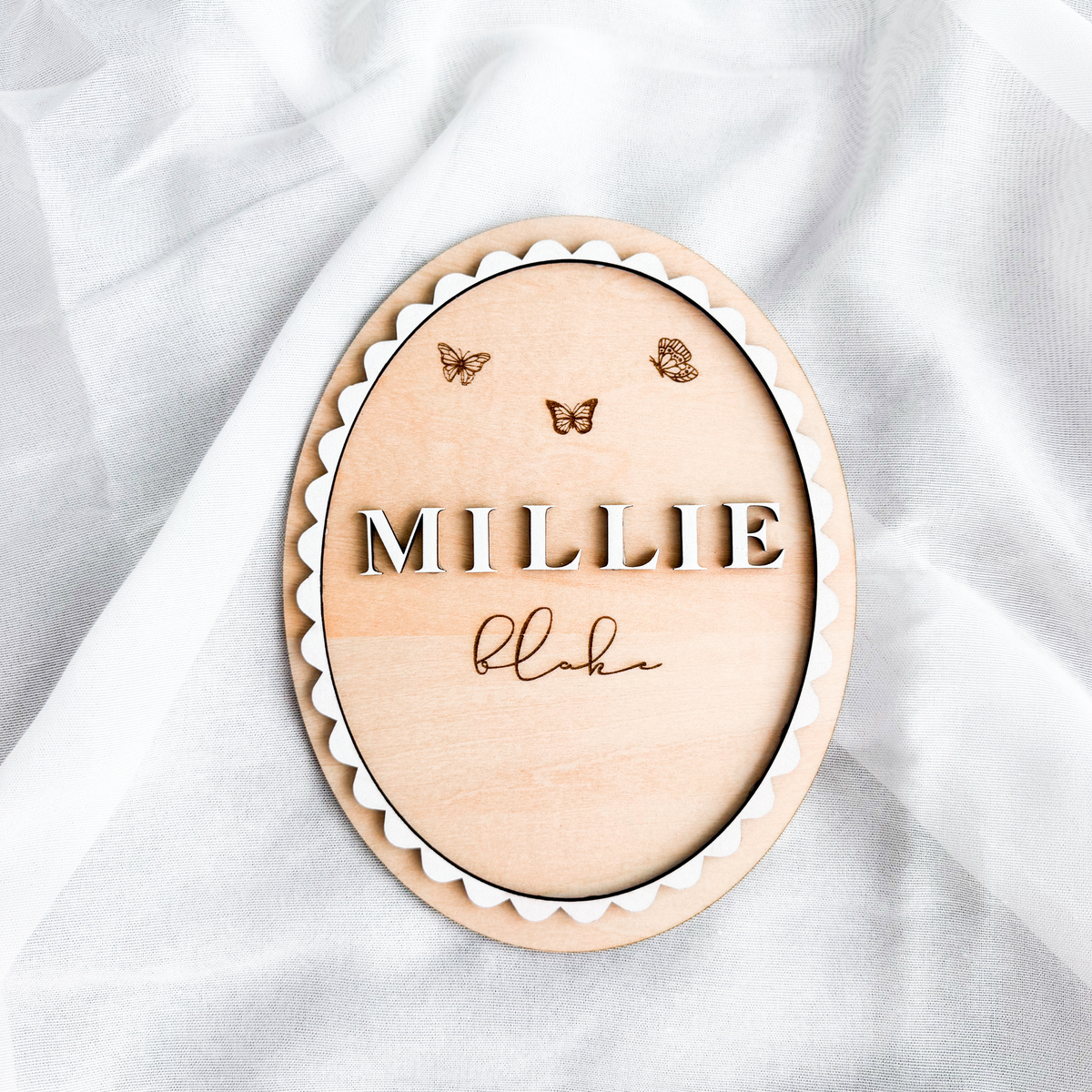 Layered scalloped birch basswood name sign with raised Millie lettering and engraved butterflies