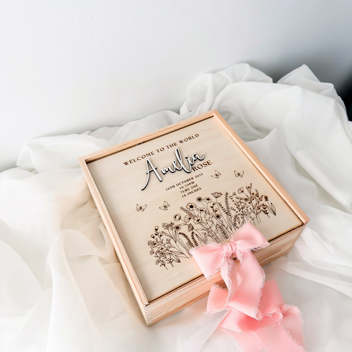 Personalized wildflower keepsake box on sheer fabric, showing the raised name lettering on the lid