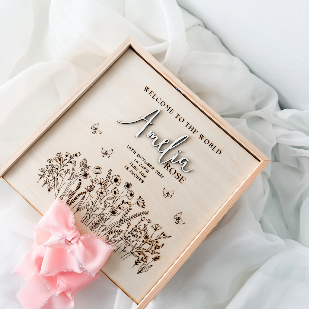 Angled view of the wildflower keepsake box lid with engraved meadow, butterflies and birth details