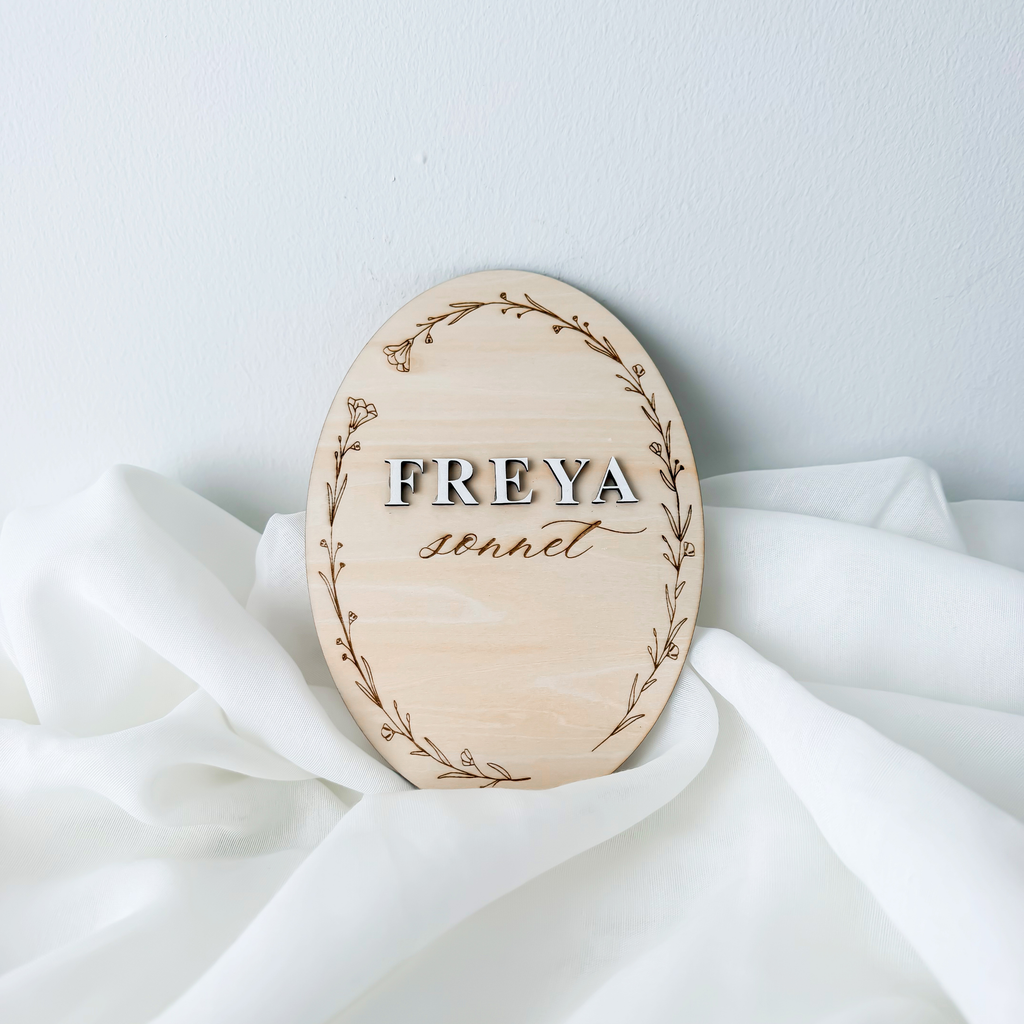 Raised letter baby name sign on birch basswood with an engraved wildflower wreath border